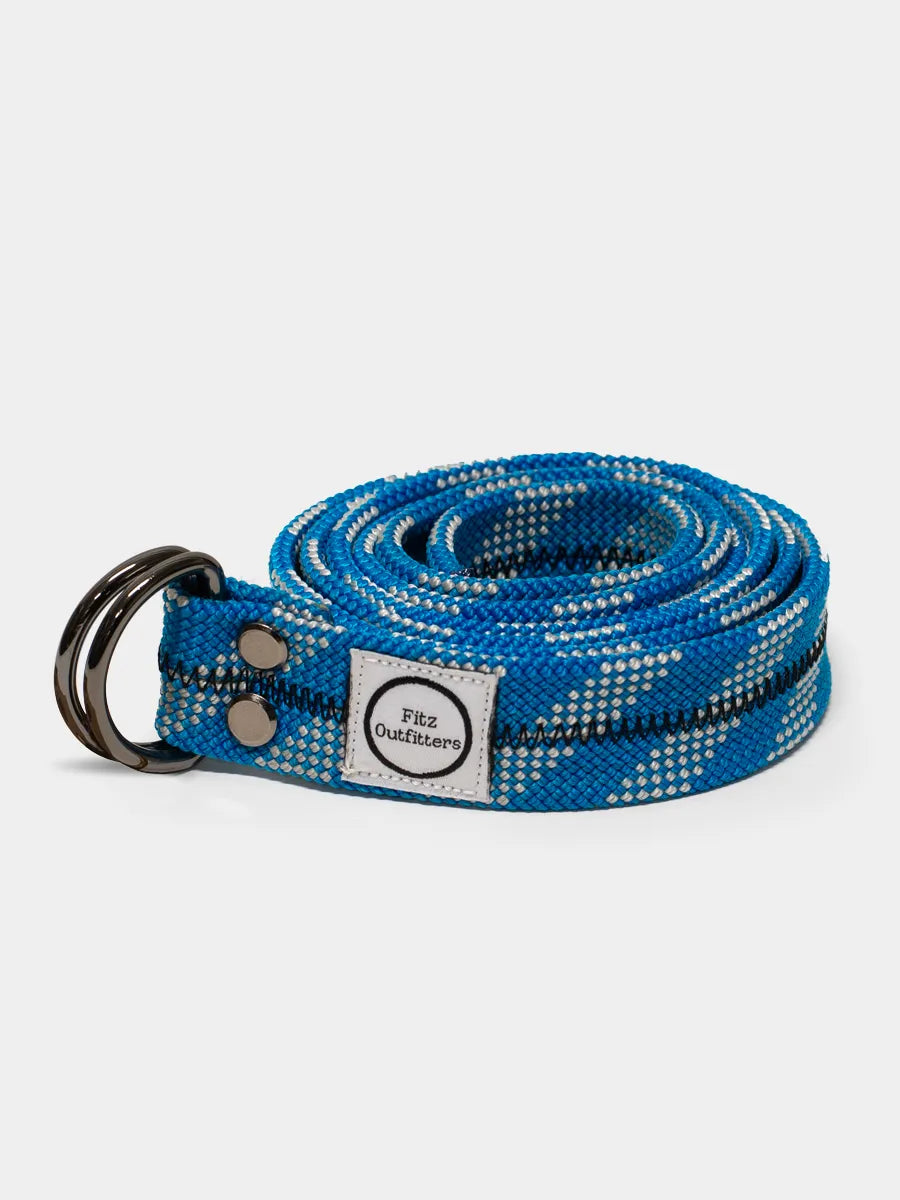 A blue climbing rope belt with a metal D-ring, coiled and displayed against a white background.