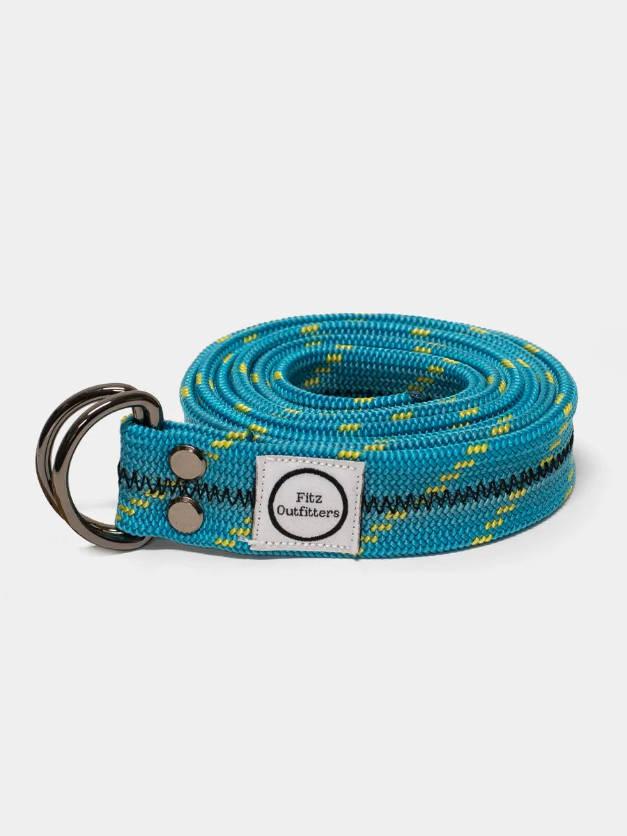 A blue climbing rope belt with a metal D-ring, coiled and displayed against a white background.