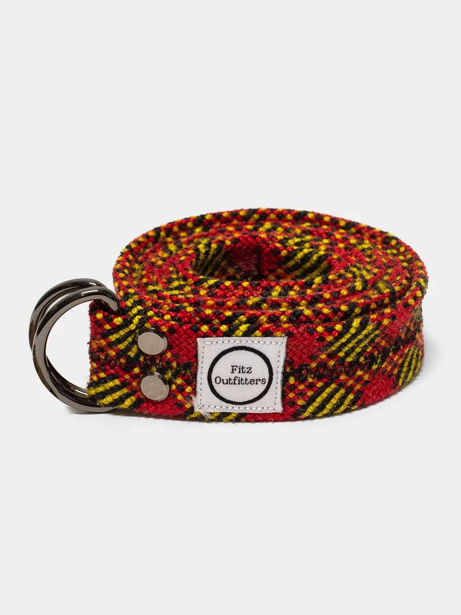 A multicolored climbing rope belt with a metal D-ring, displaying a pattern of red and yellow with black ropes. A label with the brand 'Fitz Outfitters' is visible on the belt.