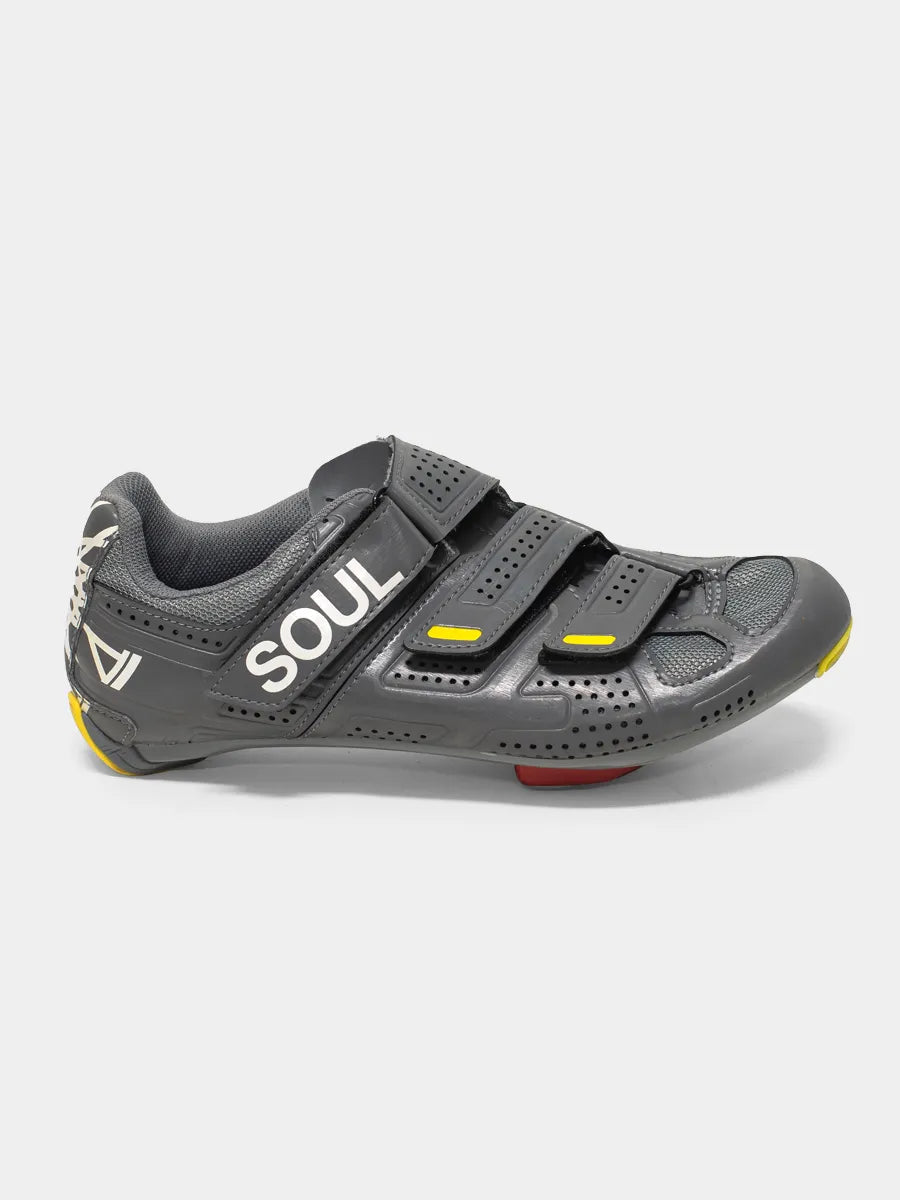 A black Pearl Izumi x Soul Cycle cycling shoe with white lettering and yellow accents.