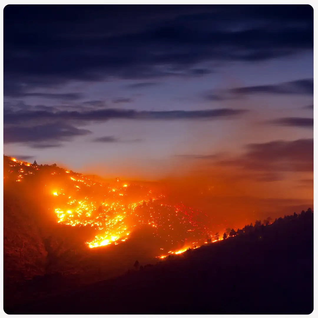 blazing orange fire in the night across the mountainside