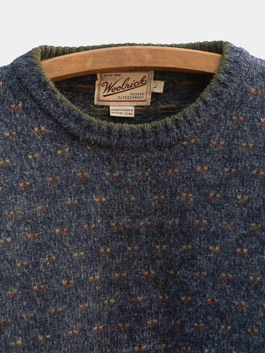 Woolrich sweater with a wooden hanger on a white background