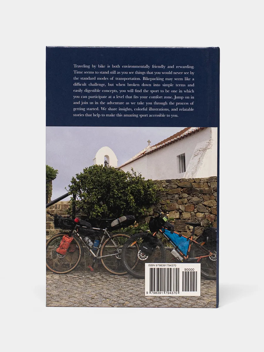 Back cover of Bikepacking Illustrated shows a photo of a bike loaded with gear against a stonewall.