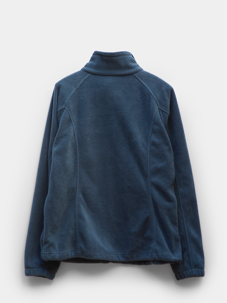 Back-facing product photo of a deep blue columbia full zip fleece jacket on a wooden hanger against a light gray background. soft fleece texture with stand collar, zip closure, and side pockets visible. clean, minimal presentation with no visible wear.