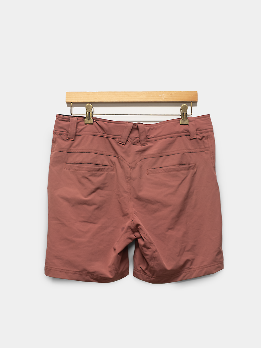 Brown shorts on a hanger against a white background