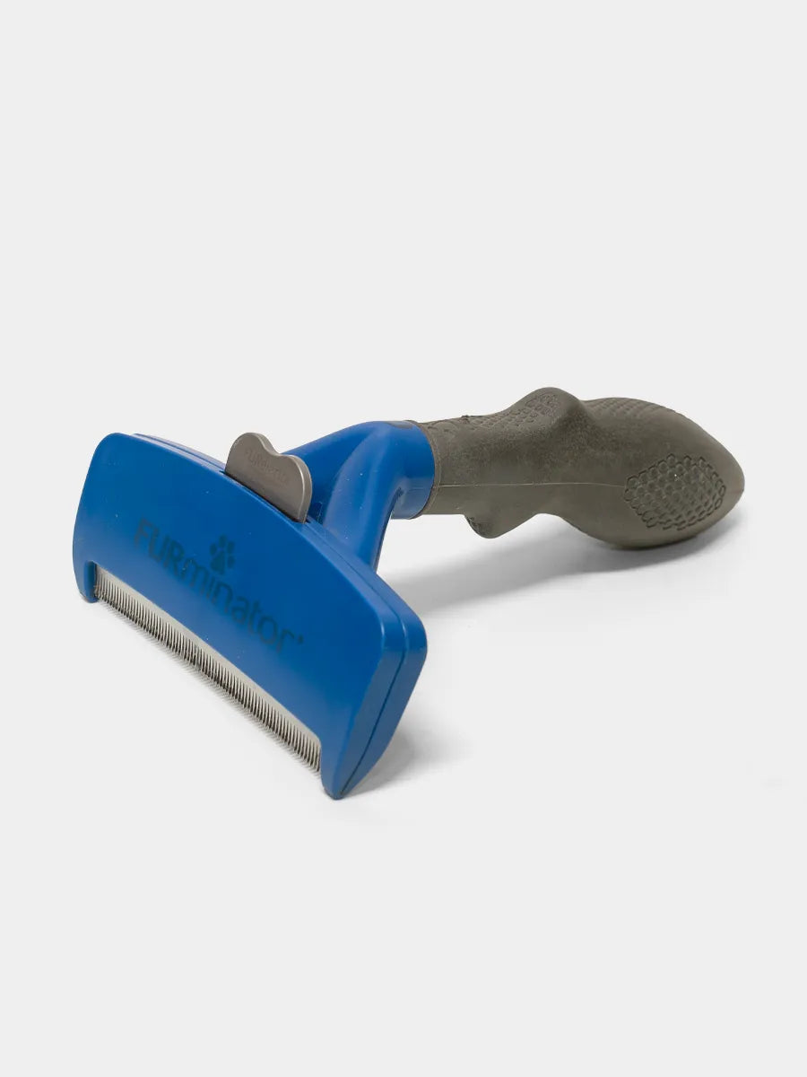 Furminator Pet grooming brush with blue handle and gray bristle side on a white background