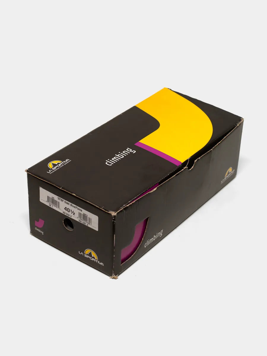 Original manufacturer's box of La Sportiva Otake Blue Flame climbing shoes. Box is black with yellow graphics and La Sportiva logo.