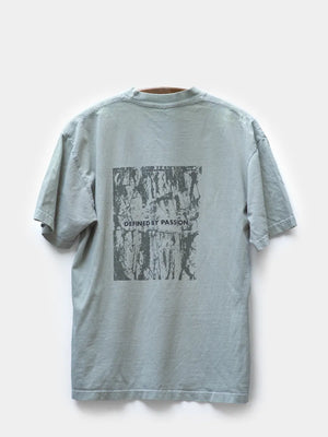 Blue Gray short sleeve T shirt with grayish black screenprint graphic art “defined by passion”.