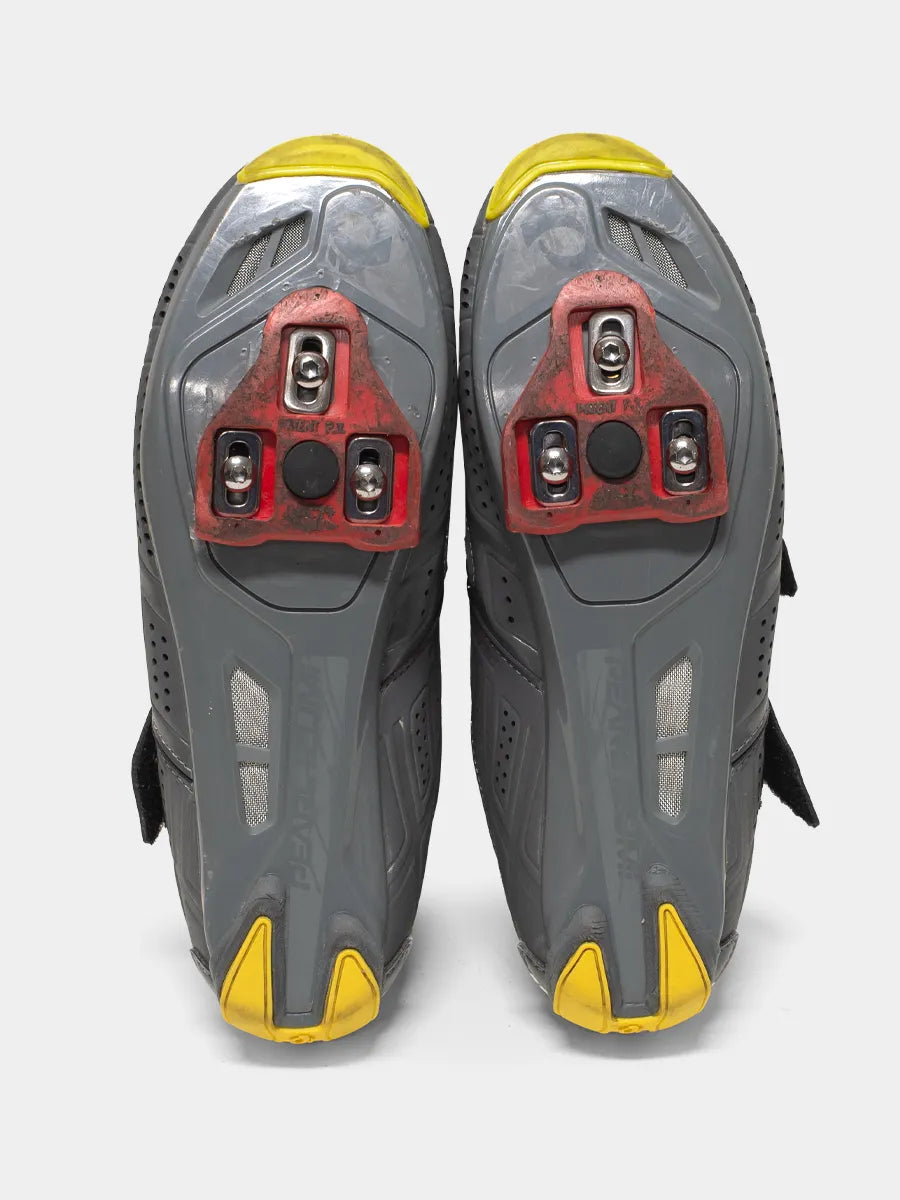 Bottom view of gray and yellow cycling shoes