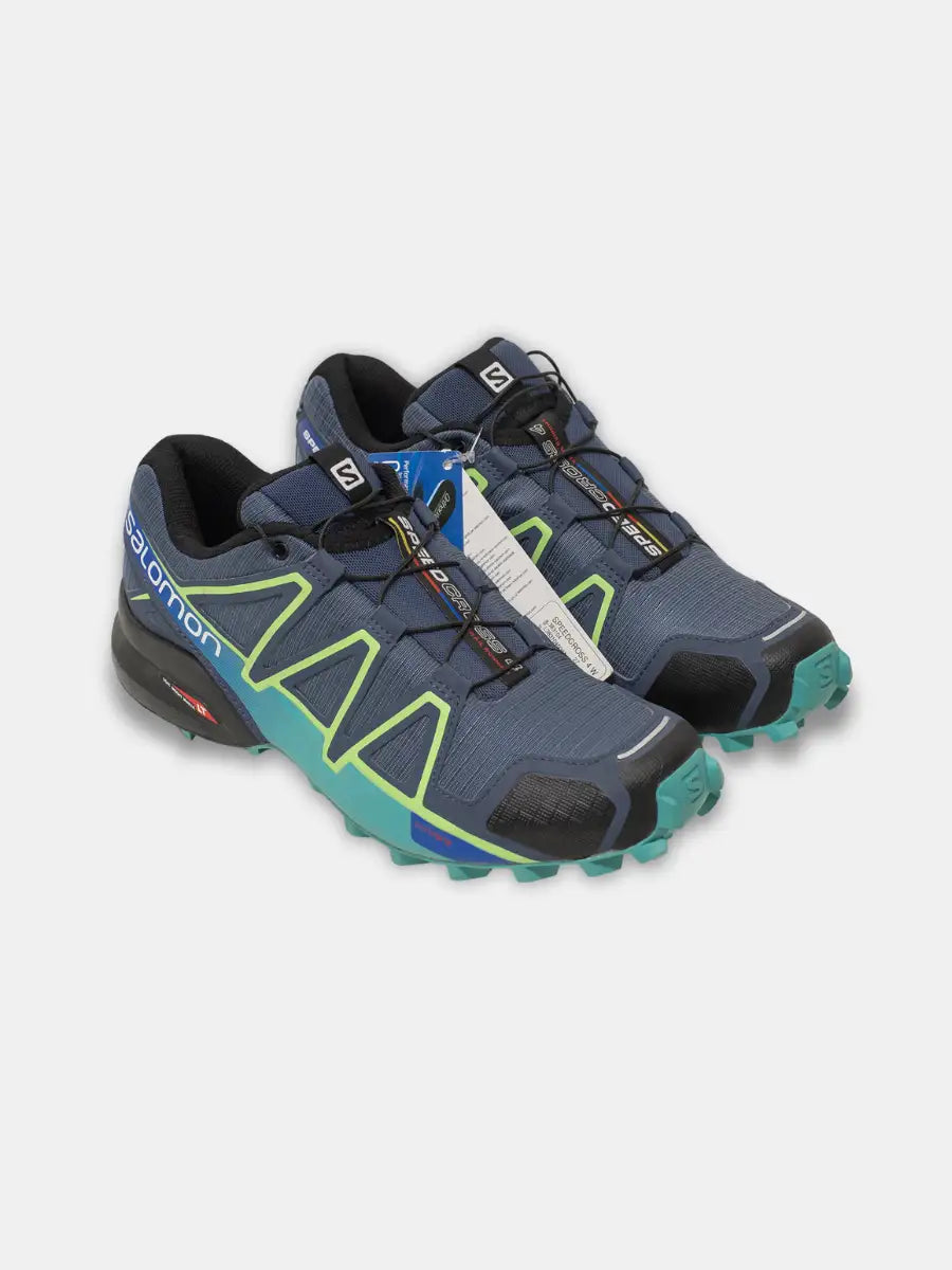Pair of new Salomon Speedcross 4 women’s trail running shoes in navy with lime green accents and aqua soles, tags attached, on white background.