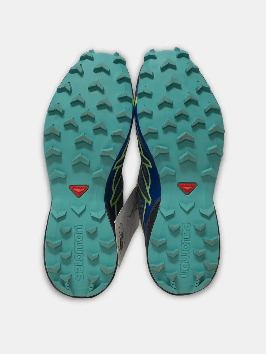 Sole View Pair of new Salomon Speedcross 4 women’s trail running shoes in navy with lime green accents and aqua soles, tags attached, on white background