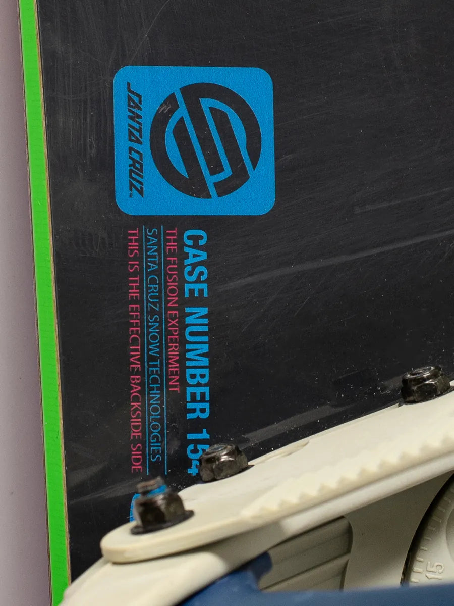 Close-up of Santa Cruz Fusion TT snowboard 154cm with Lamar MX25 bindings, showing Santa Cruz logo, neon green edge, and board tech details.