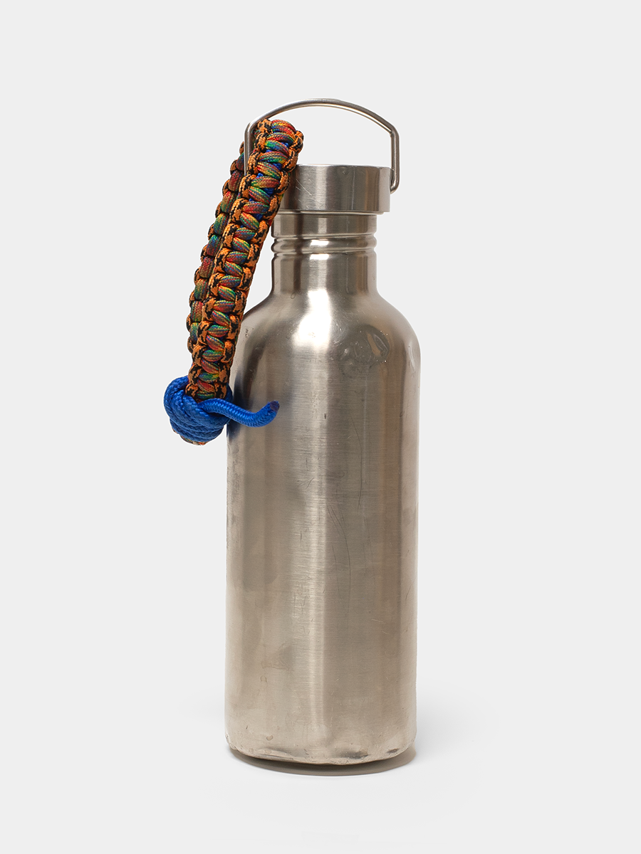 Silver water bottle with a colorful paracord handle on a white background
