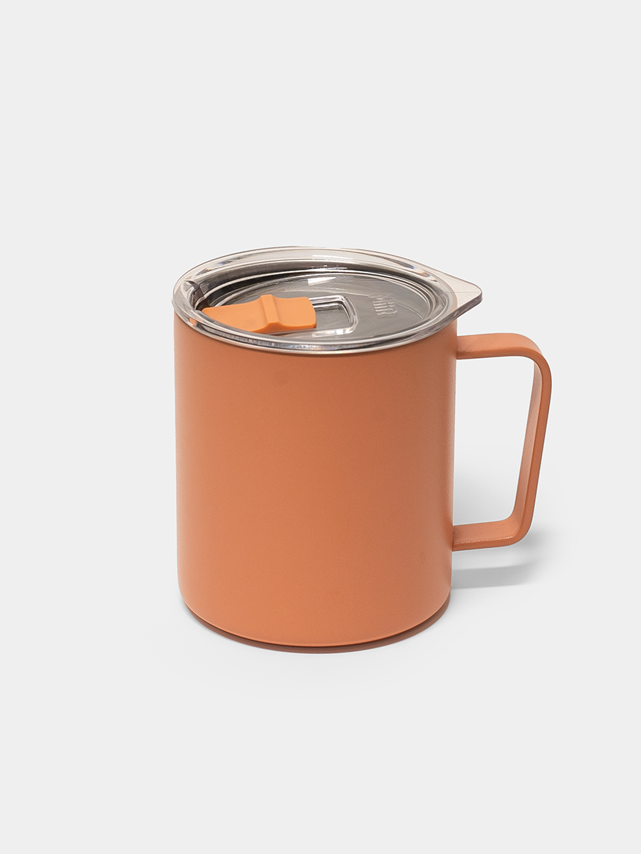 Orange mug with a lid on a light gray background