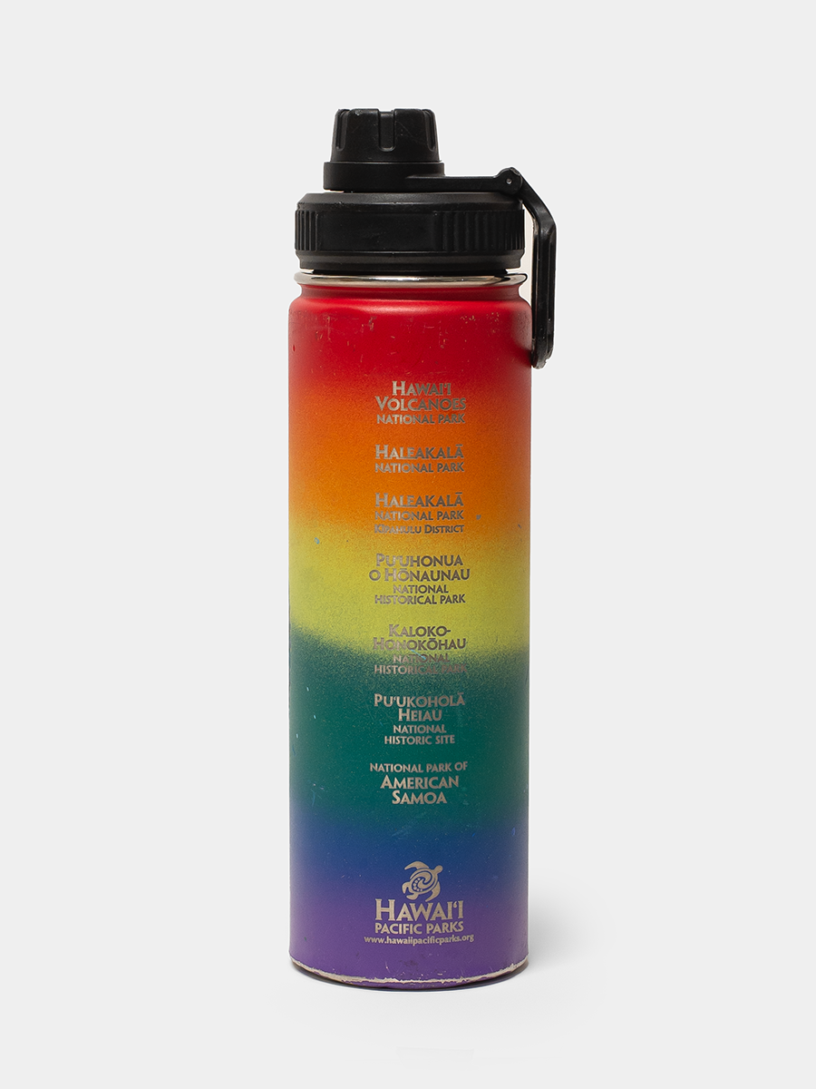 Multicolored water bottle with black cap on a white background
