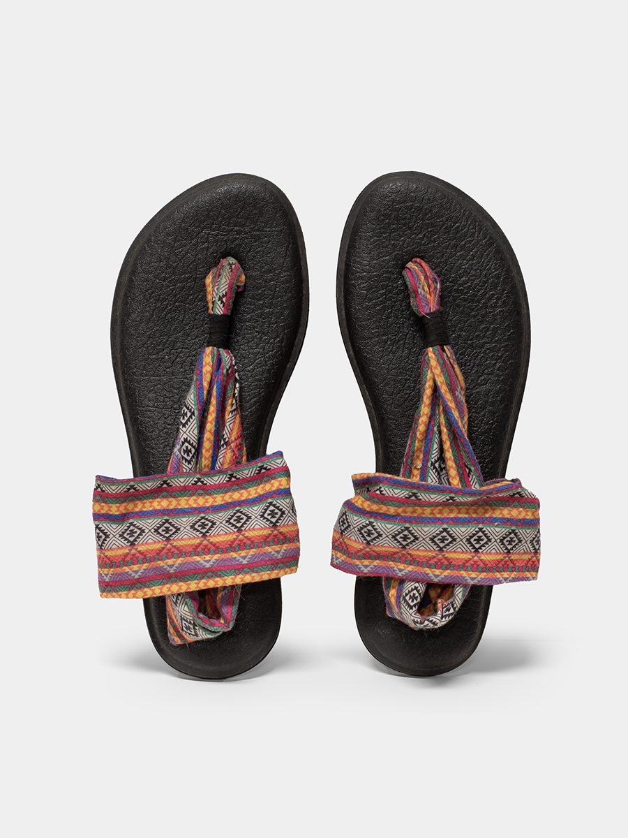 Pair of black sandals with colorful straps on a light gray background