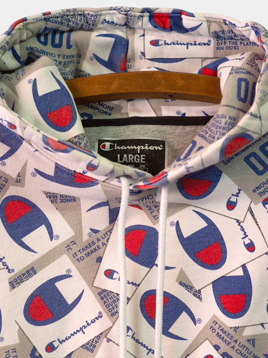 Close-up of a Champion branded hoodie with logo patterns.