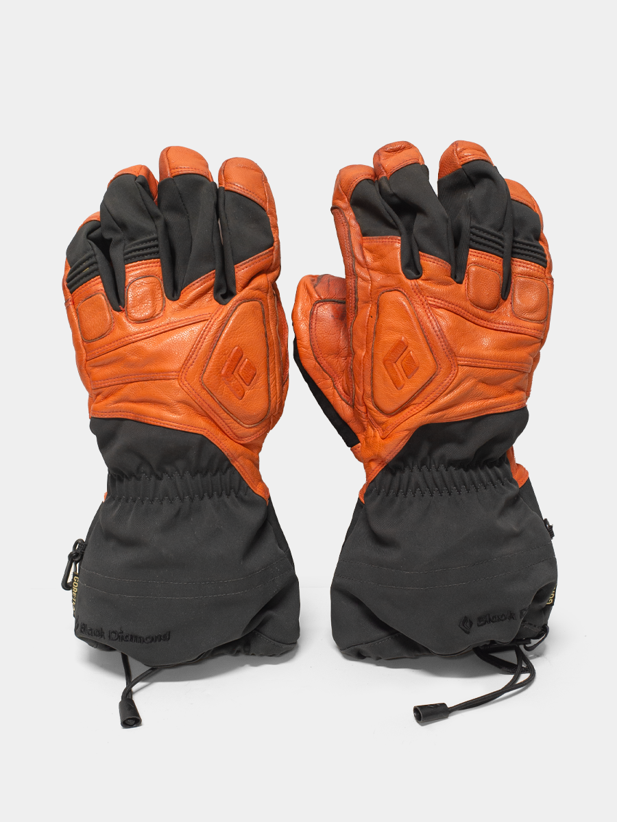 Pair of orange and black black diamond gloves on a white background